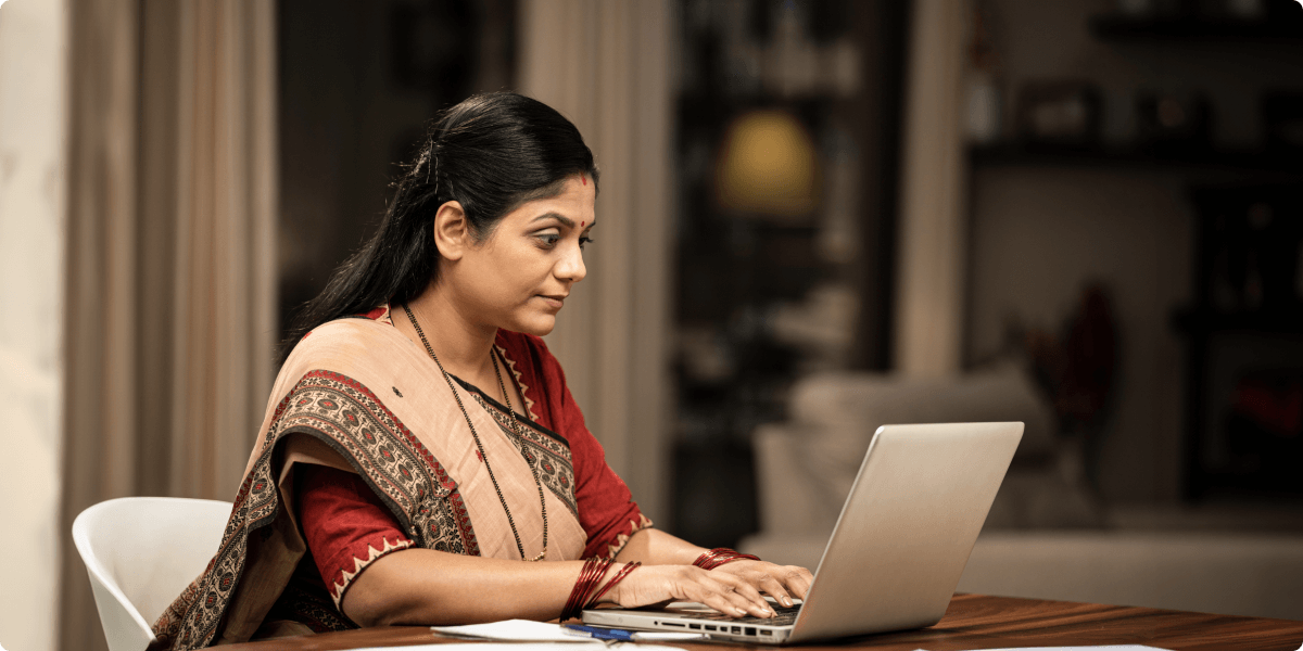 A woman working on her laptop at night.